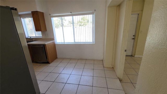 kitchen with dishwasher, light tile patterned floors, and sink