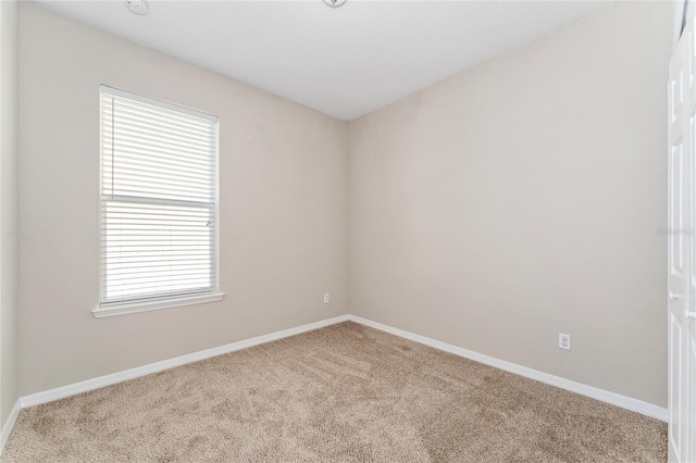 carpeted spare room featuring a wealth of natural light