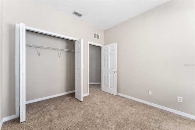 unfurnished bedroom featuring carpet flooring and a closet