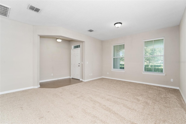 carpeted empty room with a textured ceiling