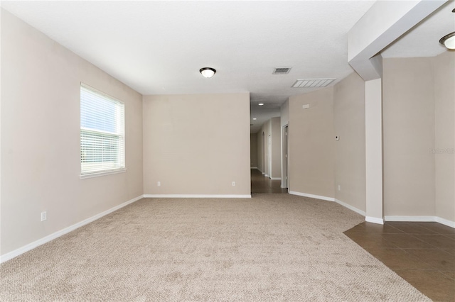 spare room featuring dark colored carpet