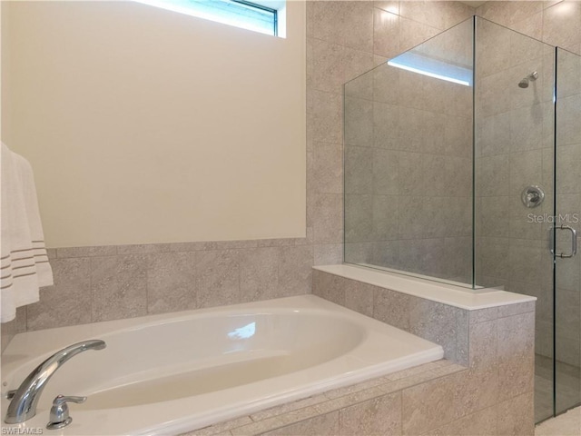 bathroom featuring shower with separate bathtub