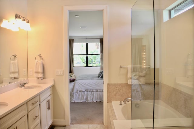 bathroom with vanity, tiled bath, and tile patterned flooring