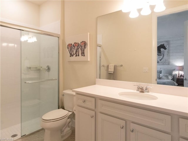 bathroom featuring vanity, toilet, and a shower with door