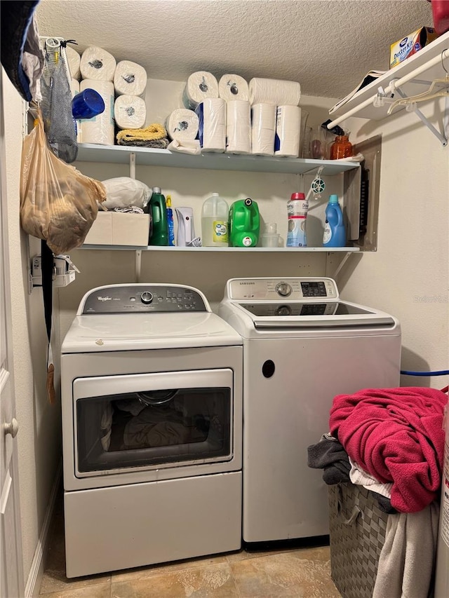 clothes washing area with a textured ceiling and washer and clothes dryer