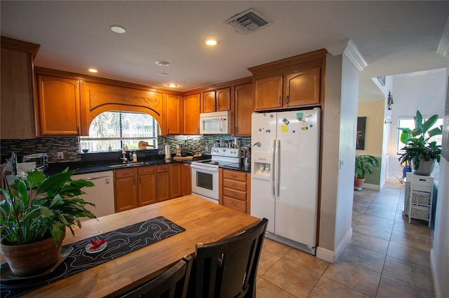 kitchen with decorative backsplash, white appliances, ornamental molding, and sink