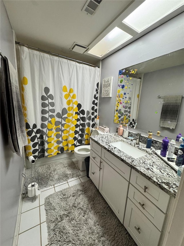 bathroom featuring curtained shower, tile patterned flooring, vanity, and toilet