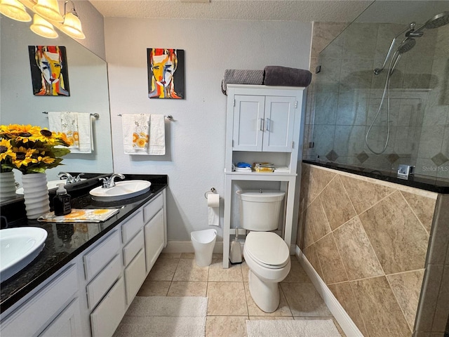 bathroom featuring tile patterned flooring, vanity, toilet, and walk in shower