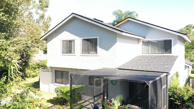 rear view of property featuring glass enclosure