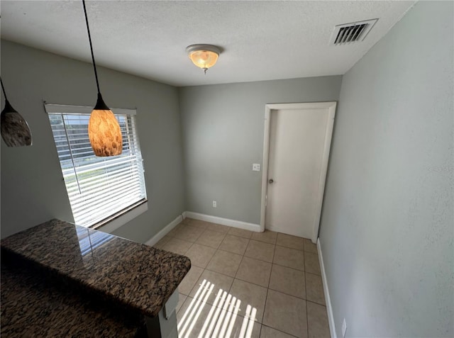 dining room featuring light tile patterned flooring and a textured ceiling