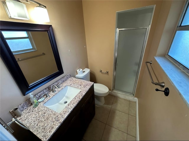 bathroom with toilet, vanity, tile patterned floors, and a shower with door