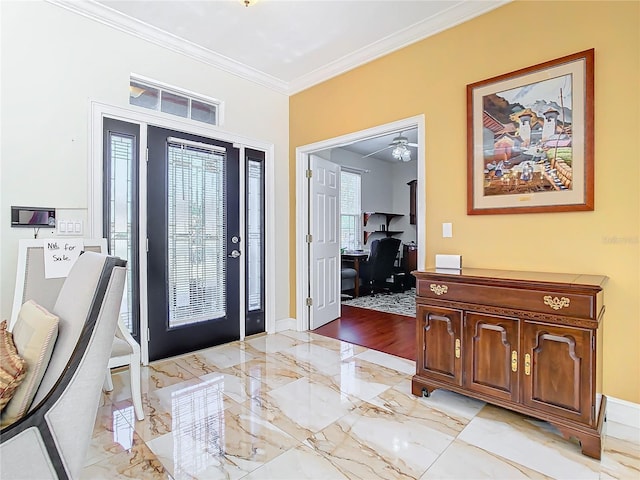 foyer with ceiling fan and crown molding