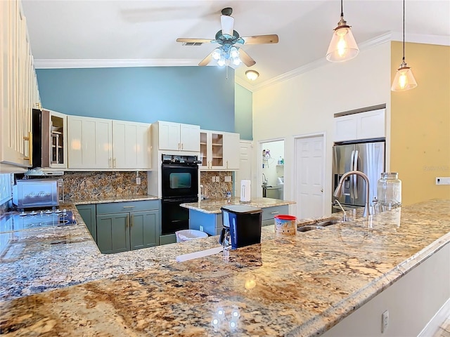 kitchen featuring light stone counters, black appliances, white cabinets, a kitchen island, and hanging light fixtures