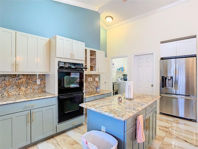 kitchen with stainless steel refrigerator with ice dispenser, a towering ceiling, double oven, a center island, and white cabinetry