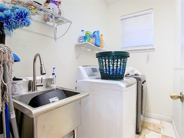 clothes washing area with independent washer and dryer and sink