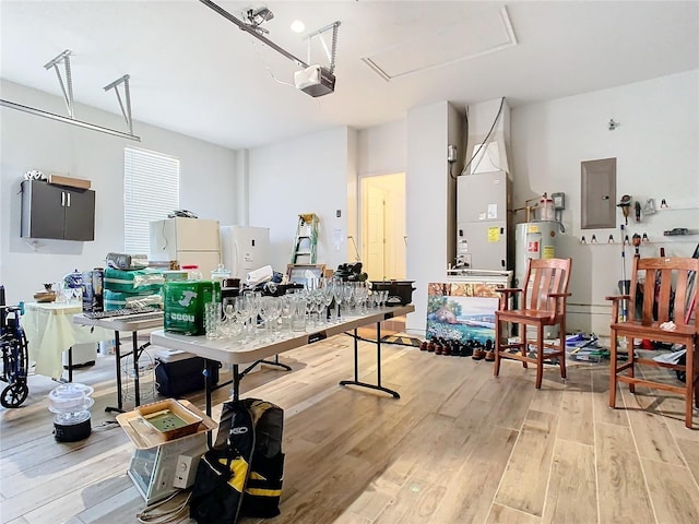 interior space with water heater, white refrigerator, electric panel, heating unit, and a garage door opener