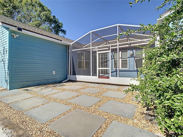 rear view of property with a patio and glass enclosure