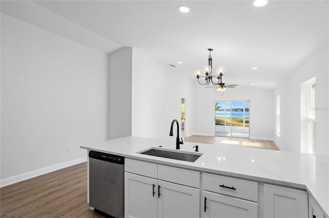 kitchen featuring stainless steel dishwasher, lofted ceiling, white cabinetry, and sink