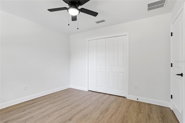 unfurnished bedroom featuring ceiling fan, light hardwood / wood-style floors, and a closet