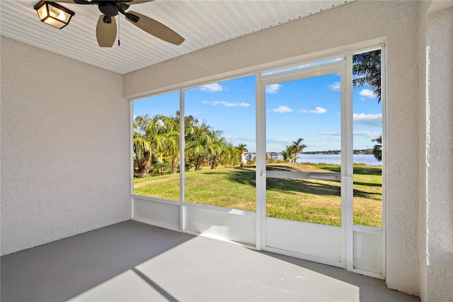 sunroom / solarium with a water view, plenty of natural light, and ceiling fan