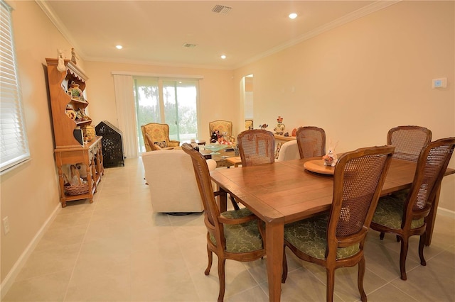 dining space featuring ornamental molding and light tile patterned floors