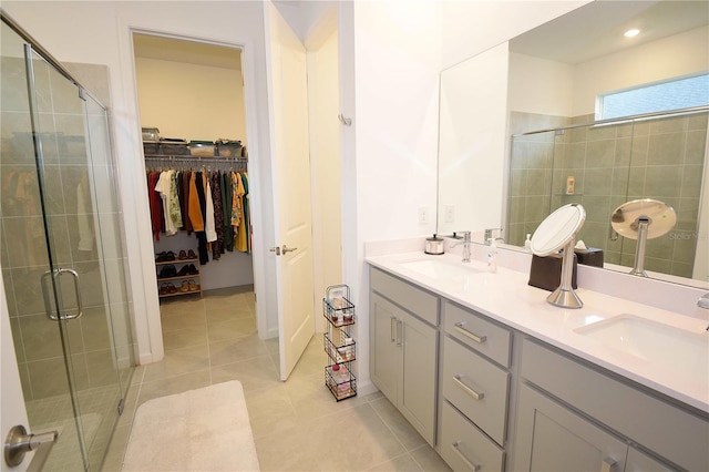 bathroom with tile patterned flooring, vanity, and walk in shower