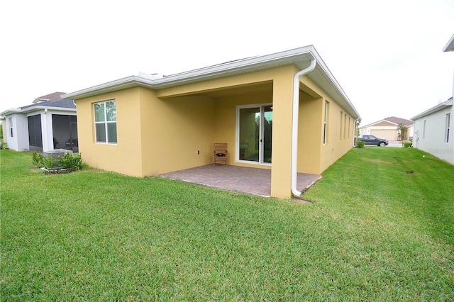 back of property with a patio area and a yard