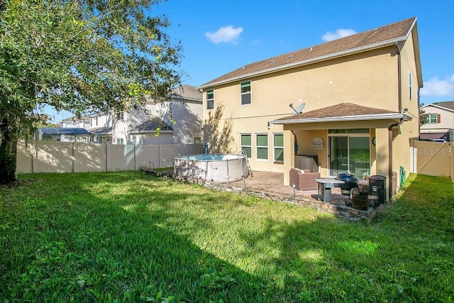 back of house featuring a patio, a fenced in pool, and a lawn