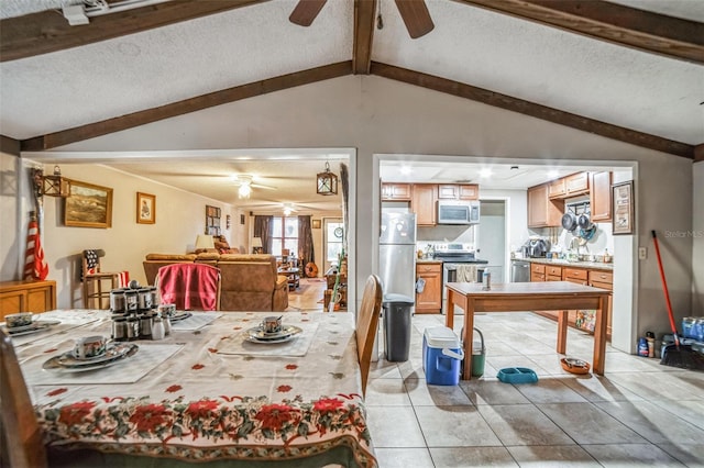 dining area featuring a textured ceiling, vaulted ceiling with beams, light tile patterned floors, and ceiling fan