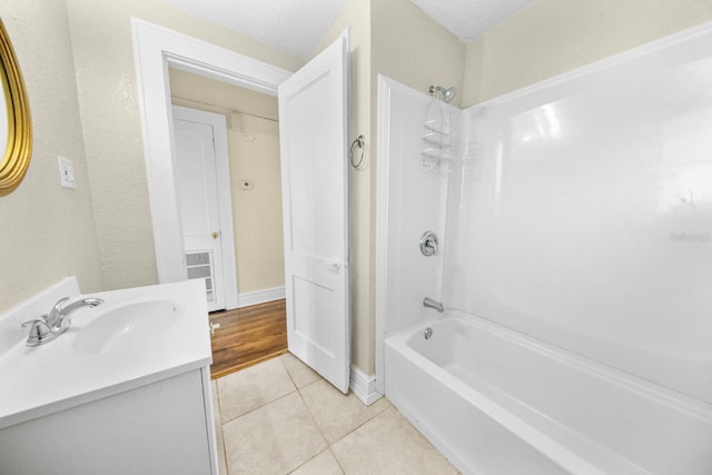 bathroom featuring tile patterned flooring, a textured ceiling, vanity, and bathing tub / shower combination