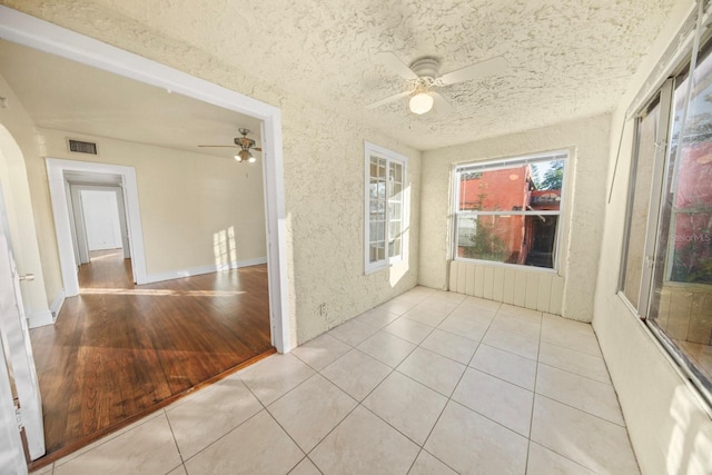 interior space featuring ceiling fan, light hardwood / wood-style flooring, and a textured ceiling