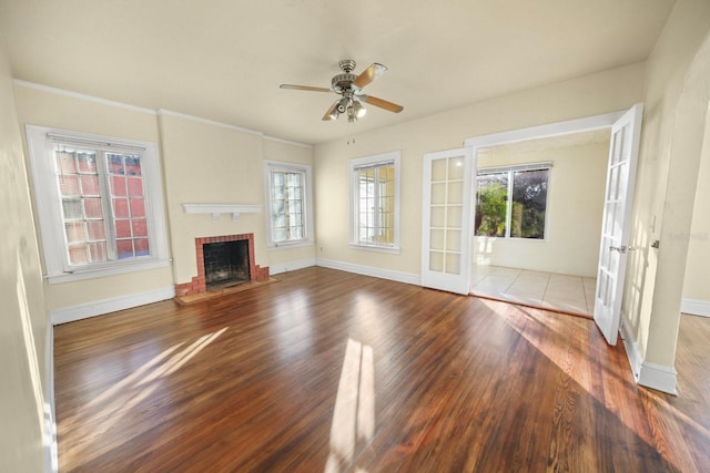 unfurnished living room featuring plenty of natural light, ceiling fan, wood-type flooring, and french doors