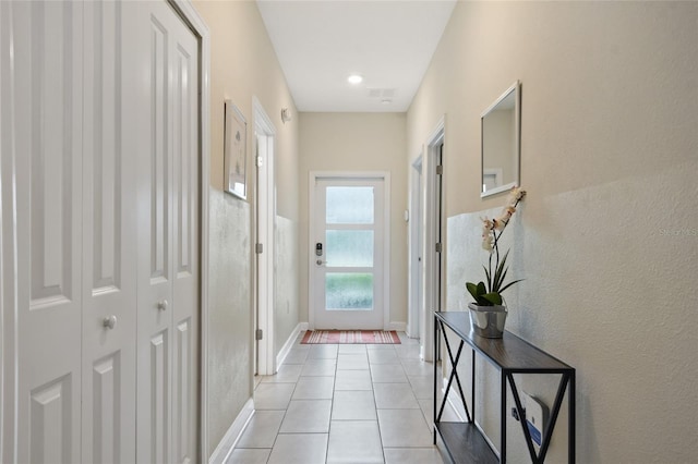 doorway with light tile patterned flooring