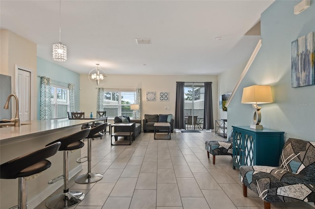 tiled living room with a notable chandelier and sink