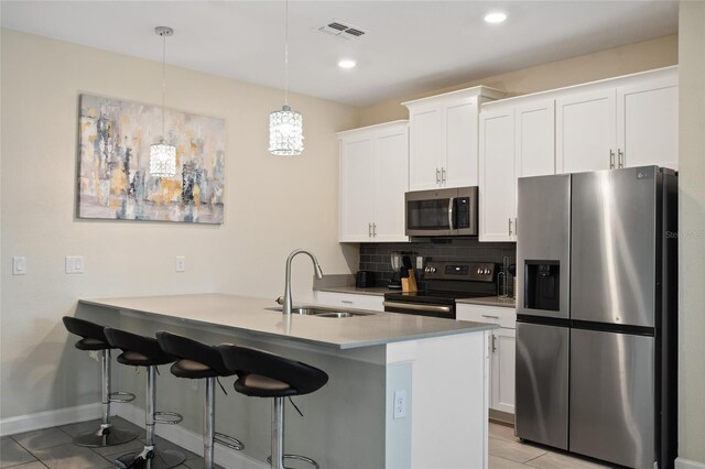 kitchen featuring sink, hanging light fixtures, stainless steel appliances, kitchen peninsula, and white cabinets