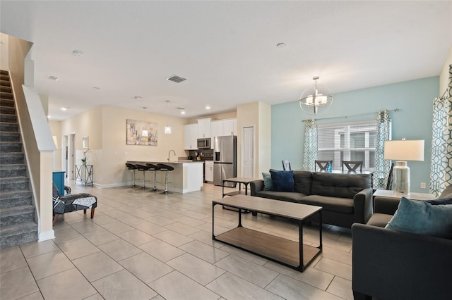 living room featuring a chandelier, light tile patterned floors, and sink