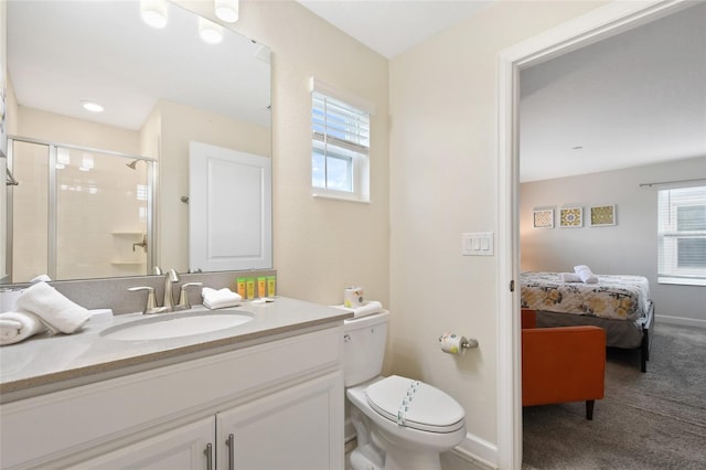 bathroom featuring vanity, a shower with shower door, and toilet