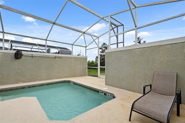 view of pool with glass enclosure and a patio area