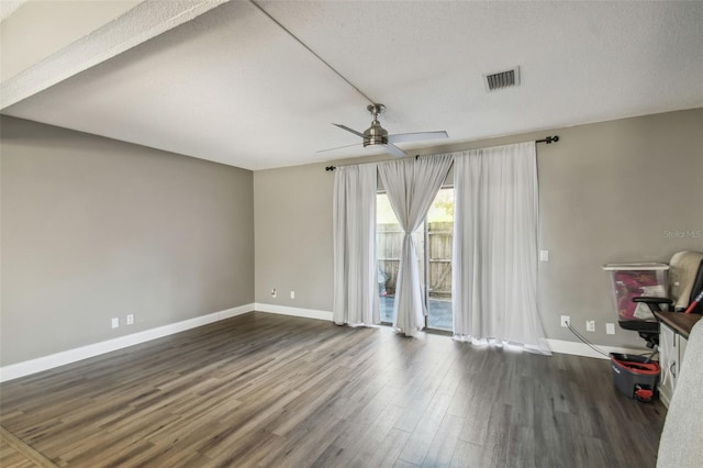 unfurnished room featuring a textured ceiling, dark wood-type flooring, and ceiling fan