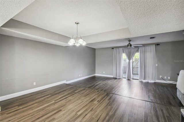 unfurnished room with ceiling fan with notable chandelier, a textured ceiling, and dark hardwood / wood-style floors