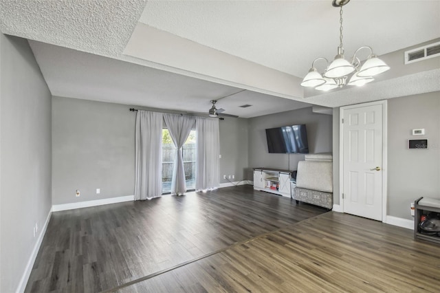 unfurnished living room featuring dark hardwood / wood-style flooring and ceiling fan with notable chandelier