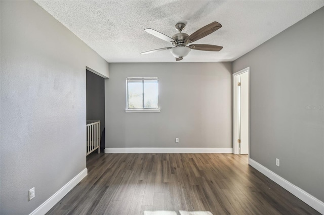 unfurnished room with ceiling fan, dark hardwood / wood-style floors, and a textured ceiling