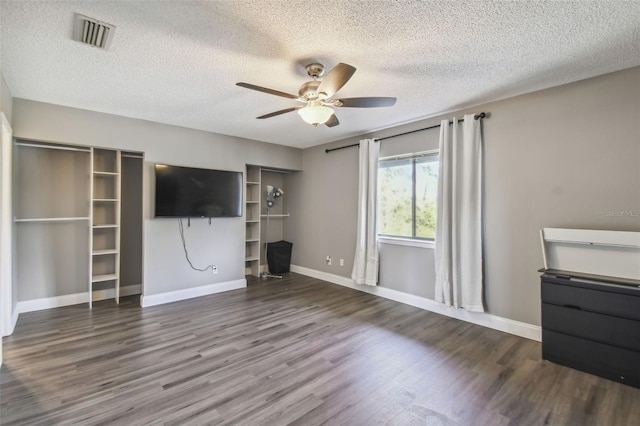 unfurnished living room with a textured ceiling, ceiling fan, and dark hardwood / wood-style flooring