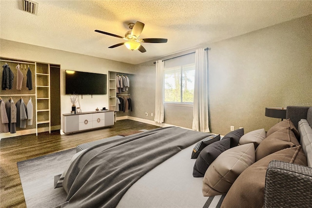 bedroom featuring ceiling fan, dark wood-type flooring, a textured ceiling, and a closet