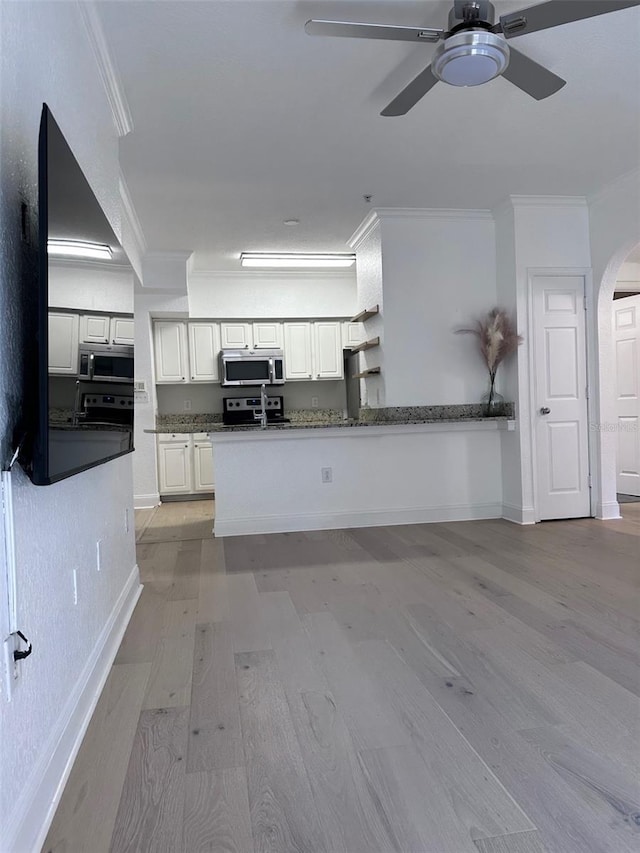 kitchen featuring kitchen peninsula, light hardwood / wood-style flooring, white cabinetry, and ornamental molding