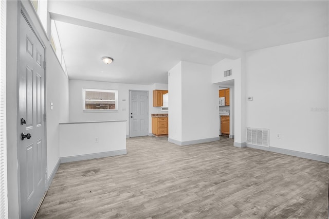 unfurnished living room with lofted ceiling with beams and light hardwood / wood-style floors