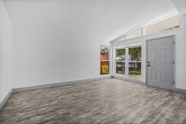 empty room featuring hardwood / wood-style floors and vaulted ceiling