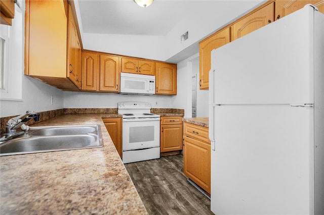 kitchen featuring white appliances, dark hardwood / wood-style floors, lofted ceiling, and sink