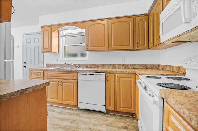 kitchen with white appliances, light hardwood / wood-style floors, and sink