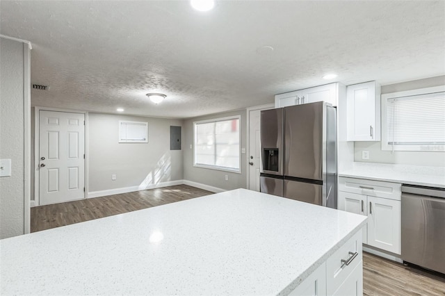 kitchen featuring white cabinets, light wood-type flooring, and stainless steel appliances